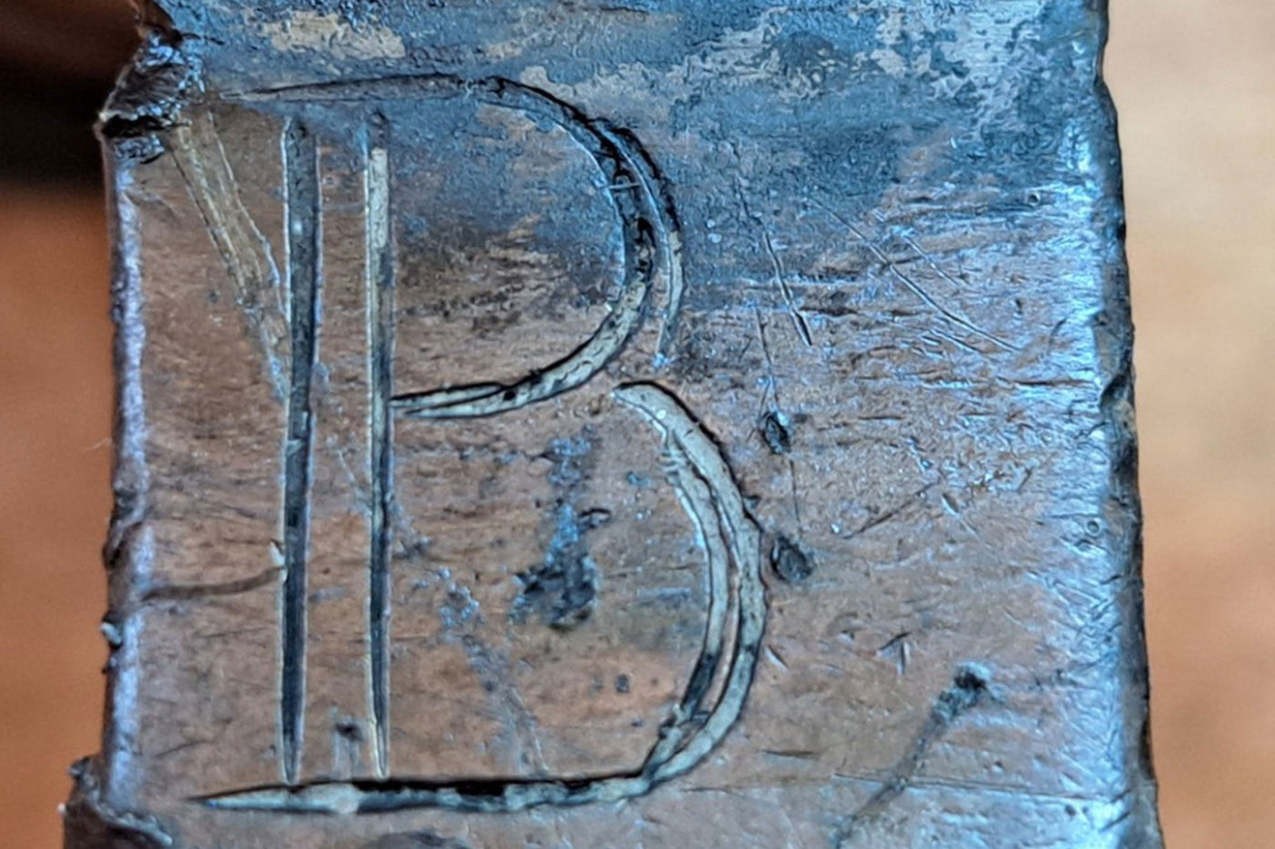 Der Buchstabe B auf einem Zinnkruggriff aus Metall eingraviert