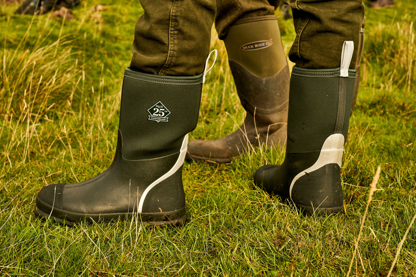 Nahaufnahme einer Person, die ein Paar Muck Boots Stiefel zum 25-jährigen Jubiläum trägt