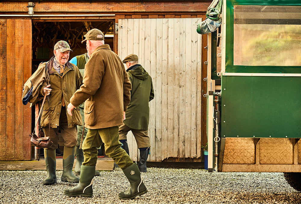 Ein paar Mitglieder des Jagdclubs “Aberdeen Lads” vor einem Gebäude, alle tragen Muck Boot Gummistiefel