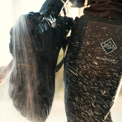 Wasser wird auf ein Paar Muck Boots gespritzt
