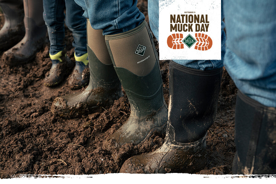 Personen in Muck Boots Gummistiefeln im Schlamm mit dem Text "National Muck Day" und einem Logo.