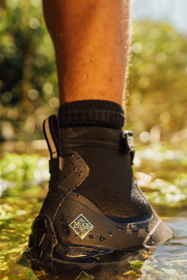 Nahaufnahme von einem Paar Muck Boots Apex Stiefel, die in Wasser stehen